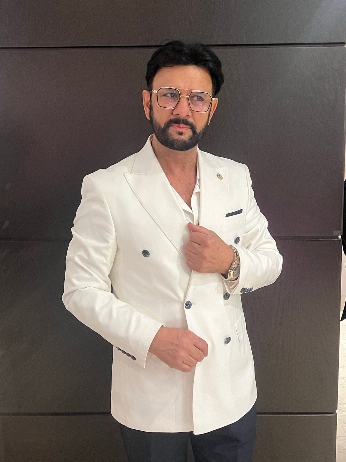 Portrait of Taher Shubab in a white double-breasted blazer